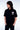 T-shirt Next Noir porté par un homme, de profil, petit logo Eleven Dripping Records rose et blanc sur la poitrine