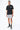 Maillot de bain Nibby Gris porté par un homme avec t-shirt noir et baskets grises, de face en pied