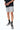 Maillot de bain Nibby Gris de face, cordon blanc, porté par un homme en t-shirt noir, chaussettes noires
