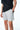 Maillot de bain Nibby Gris, plan rapproché sur le cordon et le patch coeur tonal, main dans la poche