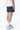 Maillot de bain Nibby Bleu nuit vu de côté et de dos, porté avec t-shirt écru et baskets bleues et blanches