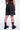 Short Ninon Noir délavé porté par une femme vu de dos, fleurs de lys brodées, chaussettes noires à coeur