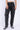 Pantalon Beleo Noir délavé porté de face, coupe droite, fleurs de lys noires sur les jambes, baskets noires et blanches