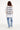 T-shirt Lys Blanc oversize porté de dos par une mannequin femme, grande inscription noire, jean bleu clair à motifs bleus