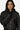Blouson Eschott Cuir Noir porté de face par une mannequin femme, cadrage serré sur l'écusson cœur et le patch
