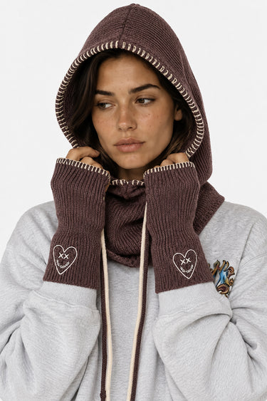 Accessoire Fanette Marron, cagoule et mitaines en maille marron portées par une femme avec sweat gris, cœurs brodés
