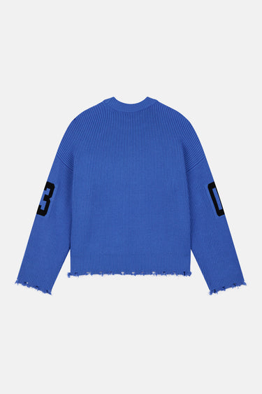 Pull Flynn Bleu en maille côtelée de dos à plat, numéros 03 noirs sur les manches, bas et poignets effilochés