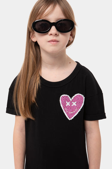 Robe enfant Jacky Noir en gros plan, cœur rose à paillettes au visage souriant sur la poitrine