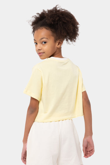 T-shirt court Jalina Jaune porté par une fille, vue de dos tournée sur le côté, short écru