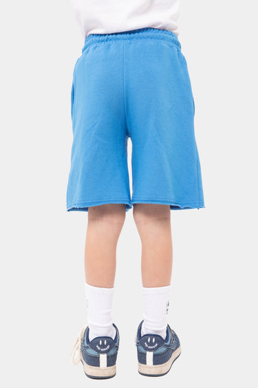 Short Jaxandre Bleu porté par un enfant, vue de dos, bas brut, chaussettes blanches et baskets bleu marine
