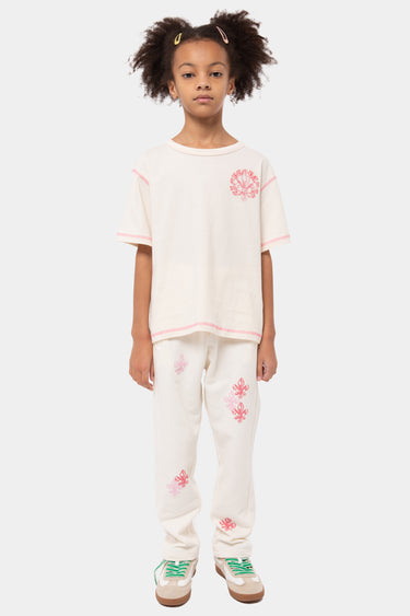 T-shirt Jea Écru porté avec le jogging assorti par une fille en pied, surpiqûres roses et lys roses