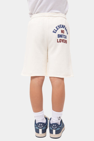 Short Jerome Écru porté par un enfant, vue de dos, inscription Eleven Paris No Snitch Lovers bleue et rouge