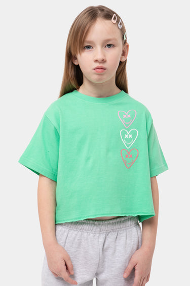 T-shirt Jilona Vert court porté par une fille, vue de face, trois cœurs à croix rose, blanc et rouge sur la poitrine