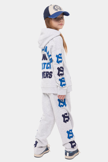 Sweat à capuche Joseph Gris Chiné porté de dos par une fille, inscriptions bleues et lettres NY appliquées sur les manches