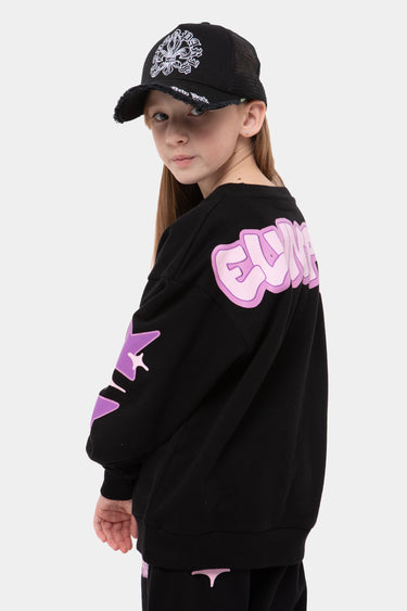 Sweat col rond Jolya Noir porté de dos par une fille, grosse inscription rose et violette Eleven, étoile sur la manche