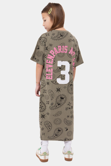 Robe longue Jonquille Kaki à motif paisley portée de dos par une fille, numéro 3 blanc, inscription rose en arc, baskets
