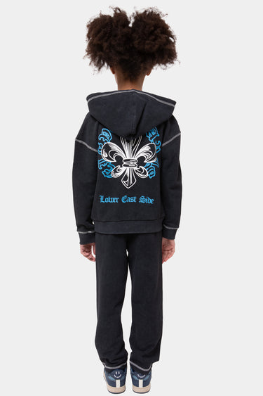 Sweat zippé à capuche Jores Noir Délavé porté de dos par une fille, grande fleur de lys blanche et bleue, Lower East Side