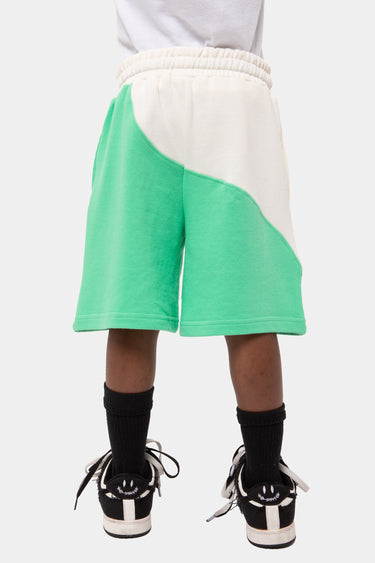 Short Jorick Vert et écru porté de dos par un enfant, empiècement incurvé, taille élastiquée, chaussettes noires