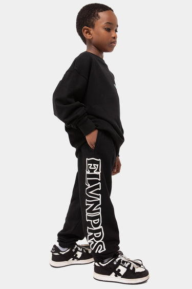 Jogging Joyau Noir porté de profil par un enfant, inscription ELVNPRS en grandes lettres blanches sur la jambe
