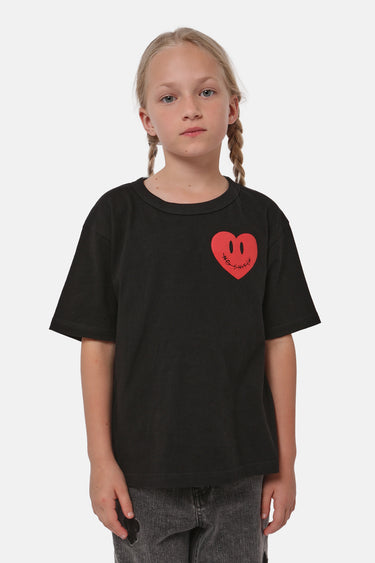 T-shirt Patras Noir porté par une fille aux tresses, vue de face, coeur rouge souriant sur la poitrine