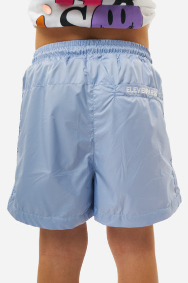 Maillot de bain Playa Bleu clair porté de dos, taille élastiquée, inscription Eleven Paris blanche sur la poche arrière