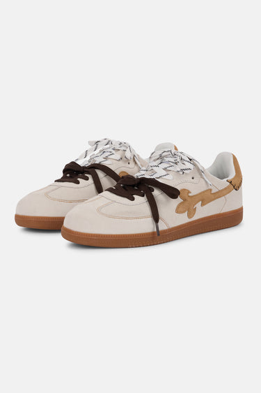 Paire de baskets Pasadena Écru en trois quarts, cuir beige, motif fleur de lys marron clair, lacets blancs et marron