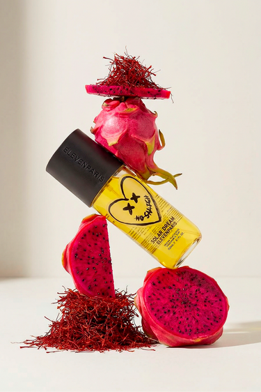 Brume parfumée Solar Dream, flacon jaune au coeur NO SNITCH posé sur des fruits du dragon et du safran