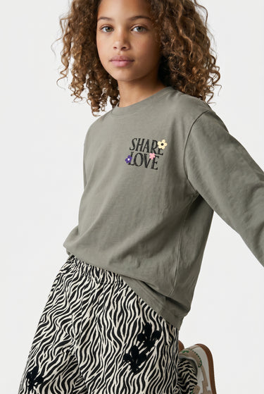 T-shirt manches longues Tag Kaki en plan resserré sur une enfant, inscription Share Love brodée de fleurs