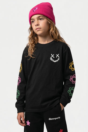 T-shirt manches longues Tam Noir en plan resserré sur une enfant, smiley NO SNITCH blanc et fleurs sur les manches