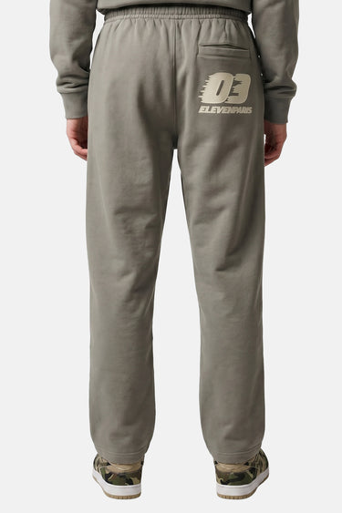 Jogging Tiki Laurier porté de dos, inscription 03 Elevenpans sur la poche arrière et baskets camouflage