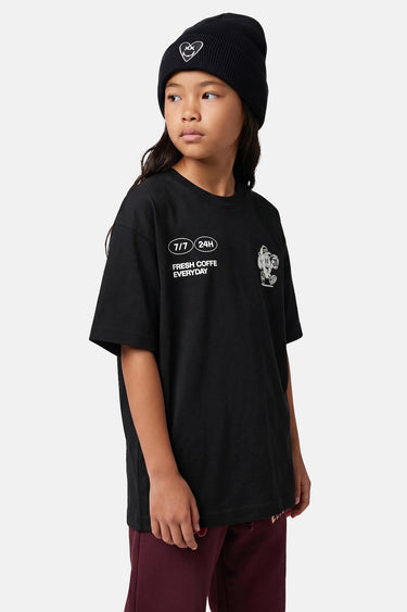 T-shirt Tolan Noir porté de face par une fille avec bonnet noir, petit motif blanc sur la poitrine