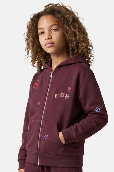 Sweat à capuche zippé Tores Bordeaux porté par une fille, fleurs brodées et logo Eleven Paris sur la poitrine