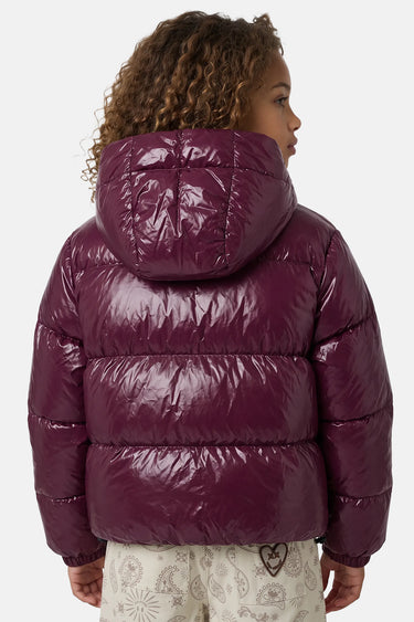 Doudoune à capuche Toupie Burgundy bordeaux brillant portée de dos par une enfant aux cheveux bouclés