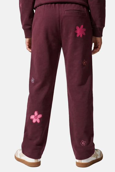 Jogging Tura Cherry bordeaux porté de dos par un enfant, poche arrière et grandes fleurs roses brodées