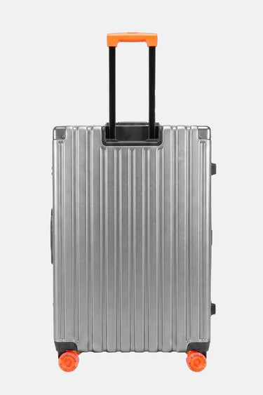 Valise Fugers Argent M vue de dos, coque rainurée gris argenté, poignée télescopique et roulettes orange